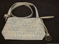 Front view of Michael Kors monogram purse showing logo charm and pattern