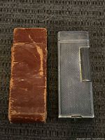 Lighter beside leather sleeve showing size and wear