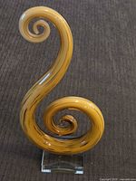 Full view of amber swirl art glass sculpture on base