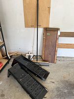 Pair of metal ramps, wood creeper, broom, dustpan in garage setting