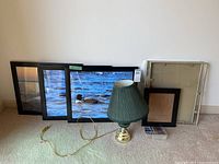 Overall lot showing framed photos, lamp, empty frames