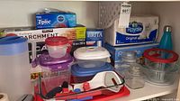 Overview of shelf with boxed consumables, containers, utensils and glass dishes