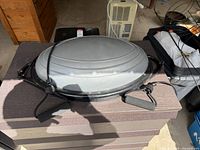 Top view of BOSU Balance Trainer showing gray dome, black base, and attached resistance bands with handles