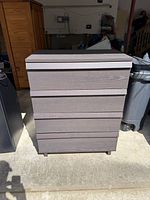 Front view of dark brown four-drawer IKEA dresser