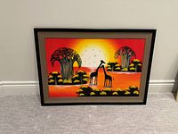 Framed African painting leaning against wall