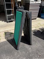 Folding pet ramp standing folded, showing side profile and hinge