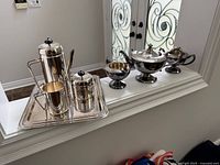 Both tea sets displayed on ledge