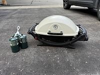 Weber Q grill front view with two propane cylinders
