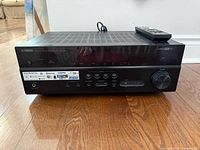 Front view of Yamaha RX-V579 receiver with remote on top