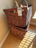 Two stacked large wicker baskets with tag