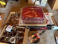 Overview of roasting pan, canning jars, egg poacher, box of lids