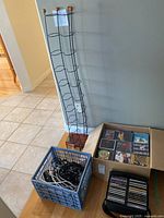 Overview of CD rack, crate of cords, box of CDs and CD binder