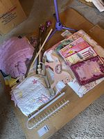 Group view of bedding, curtain rods with finials, curtain valance, books, microphone stand base