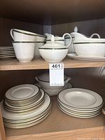 Full cabinet view showing stacks of plates, cups, gravy boat, sugar bowl