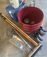 Group shot of garden tools, planters, sprayer, watering can, shoes