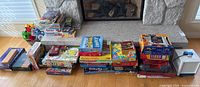 Wide view of multiple stacks of board games on hearth and floor