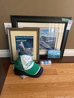 Group shot of framed prints, caps, golf balls, small plaque