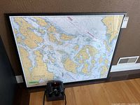 Framed nautical chart and Eaton binoculars displayed together