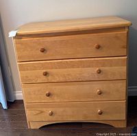 Front view of maple chest showing four drawers and knobs