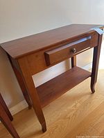 Full view of wooden hall table showing drawer, lower shelf, legs