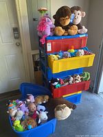 Stacked colourful plastic drawers with plush toys and open blue bin of additional toys