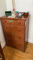 Front view of 4-drawer wooden highboy dresser