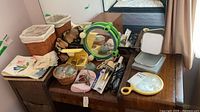 Overview of dresser top with baskets, mirrors, curling iron, grooming items and accessories