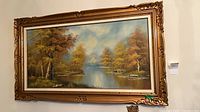 Full view of signed landscape oil painting in ornate frame