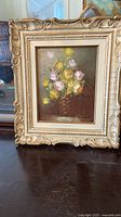 First painting with roses in basket, ornate cream/gilt frame