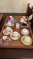 Tray with 11 teacup and saucer sets