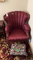 Front view of burgundy channel-tufted chair with matching footstool