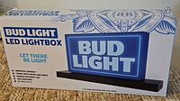Front of sealed retail box showing Bud Light LED lightbox graphics and features