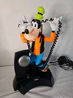 Front view of Goofy telephone on base with handset and cords