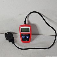 Full view of handheld Hyper Tough OBDII scanner with cable and connector