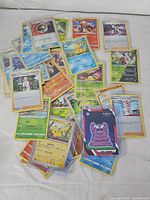 Pile of assorted holographic Pokémon cards spread on surface