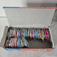 Open box showing rows of individually wrapped buttons