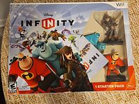 Front of boxed Disney Infinity Wii Starter Pack showing artwork and included figures visible through window
