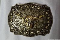 Front view of gold-tone buckle showing Longhorn head and scrollwork