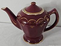 Left side view showing full teapot shape, spout, handle, and gold decoration