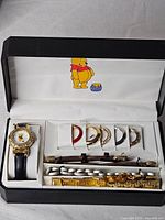 Watch set in open presentation box showing watch, bezels and straps