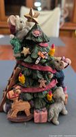 Front view of resin Christmas tree bank with mice figures, toys and presents