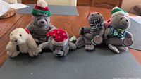 Front view of all five Coca-Cola plush seals on table