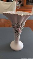 Front view of pink porcelain bud vase with floral appliqués and scalloped gold rim
