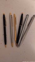Six mechanical pencils laid out on tabletop