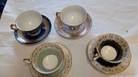 Four teacup and saucer sets displayed on table