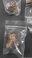 Brown glazed ceramic cat figurine in plastic bag