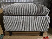 Front view of the corduroy ottoman showing cushion and ribbed fabric