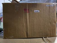 sealed but distressed cardboard box containing side table