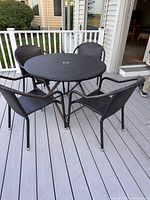 Top view of round wicker patio table with four matching chairs on deck