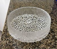 Top angle of clear textured glass bowl showing bubbled base pattern